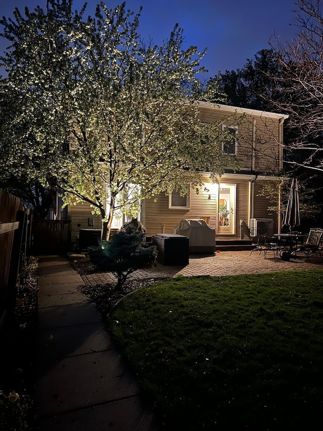 back of house featuring a yard, a patio, and fence