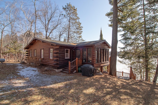 exterior space featuring log siding and a sunroom