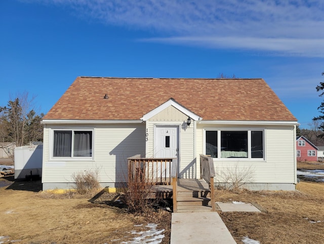 bungalow-style home with roof with shingles