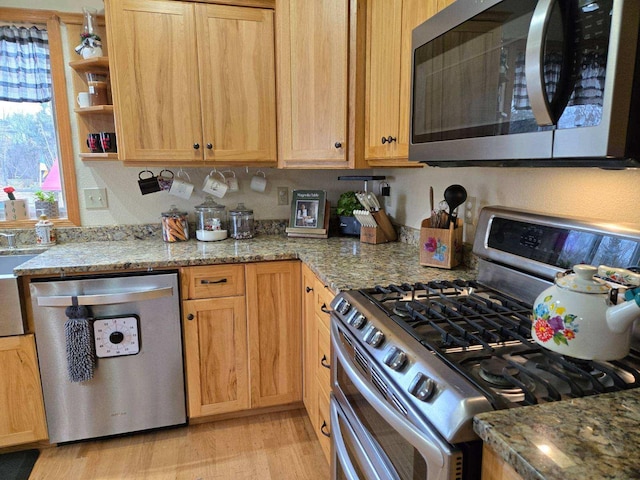 kitchen with open shelves, light wood finished floors, light stone countertops, and appliances with stainless steel finishes