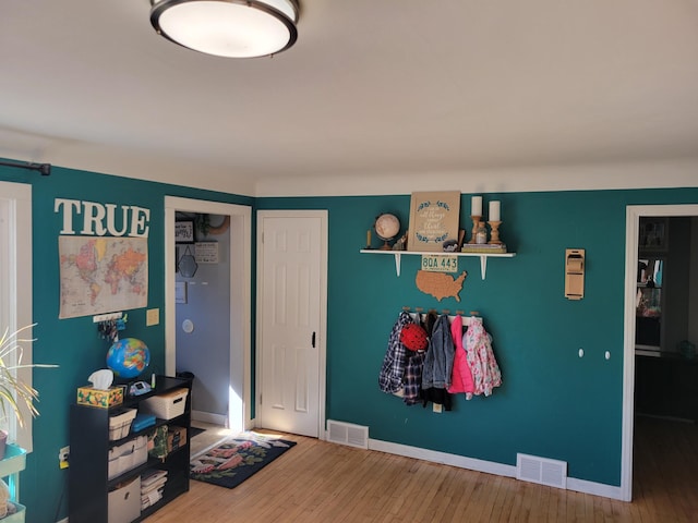 interior space with visible vents, baseboards, and hardwood / wood-style flooring