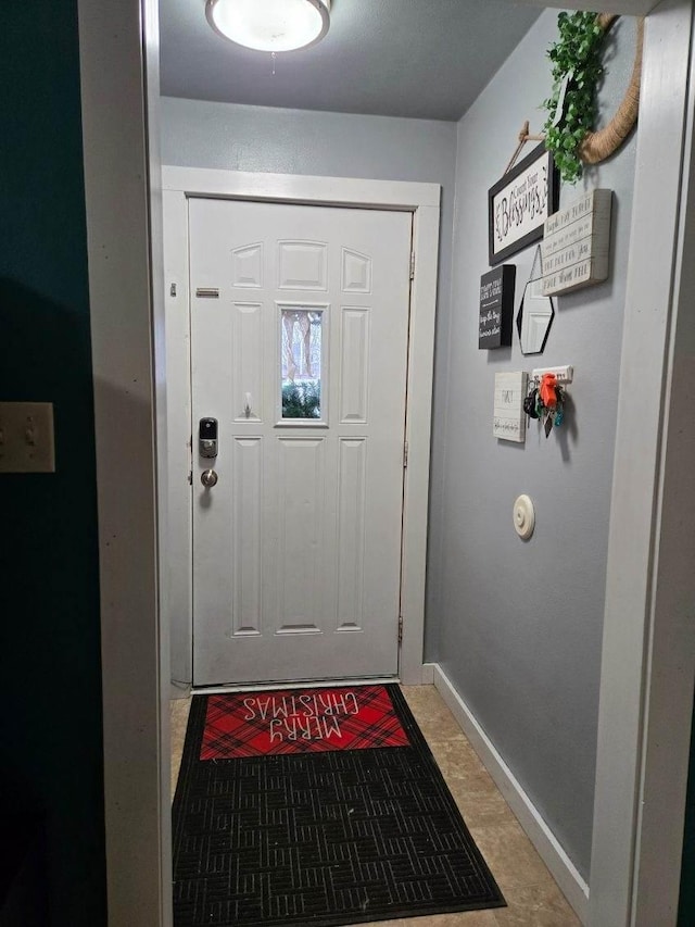 doorway featuring baseboards