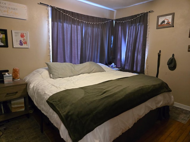 bedroom featuring baseboards and wood finished floors