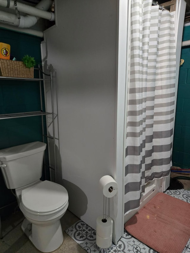 bathroom featuring curtained shower and toilet