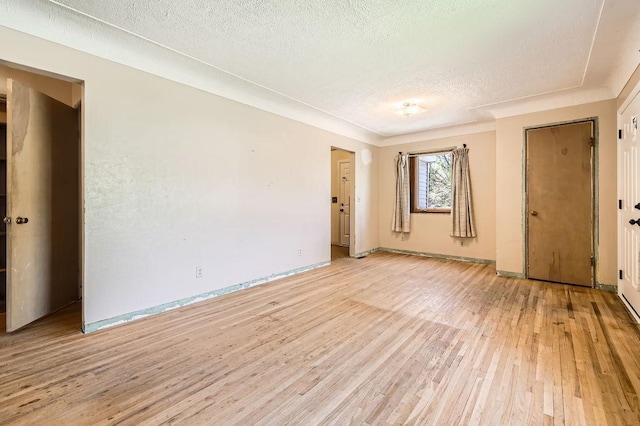 900 Park St, Anoka, MN 55303 - empty room with light wood-type flooring, a textured ceiling, and baseboards