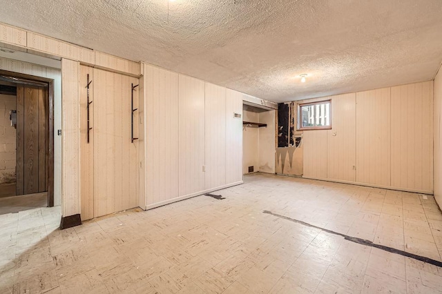 900 Park St, Anoka, MN 55303 - unfurnished room with tile patterned floors, a textured ceiling, wooden walls, and elevator