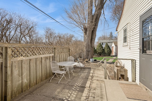 view of patio featuring outdoor dining space and fence