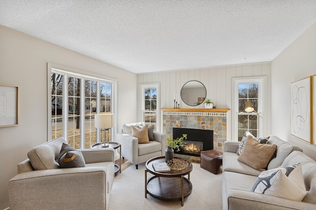 living room featuring carpet flooring, a textured ceiling, and a fireplace