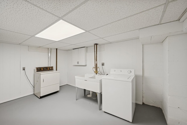 washroom featuring concrete block wall, independent washer and dryer, and laundry area