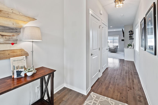 corridor with baseboards and hardwood / wood-style floors