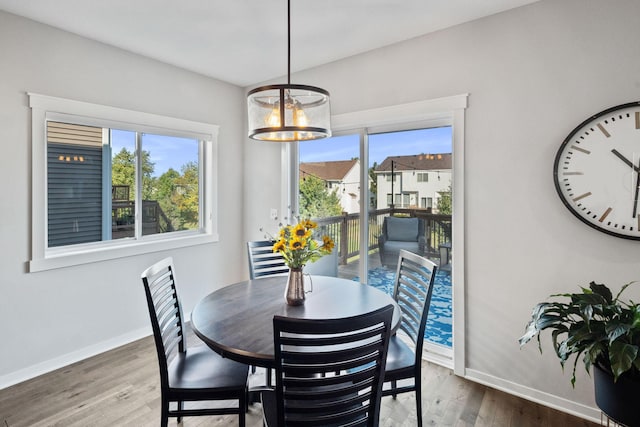 dining space featuring a notable chandelier, baseboards, and wood finished floors