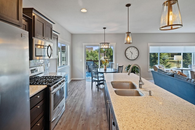 kitchen with decorative backsplash, a healthy amount of sunlight, appliances with stainless steel finishes, and a sink