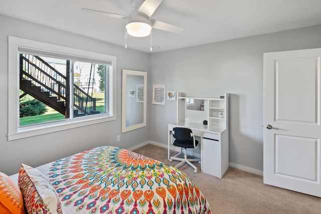 bedroom featuring baseboards, light colored carpet, and a ceiling fan