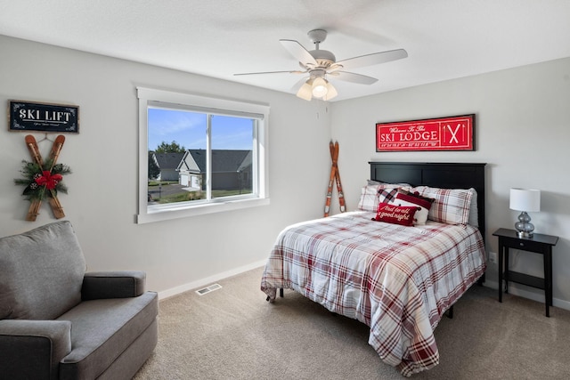 carpeted bedroom with visible vents, baseboards, and ceiling fan