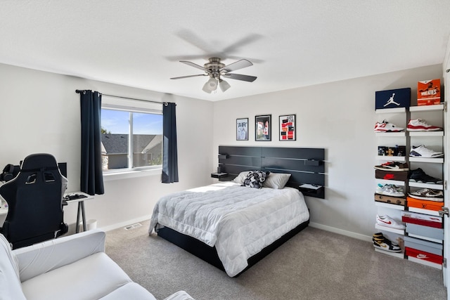 carpeted bedroom featuring visible vents, a ceiling fan, and baseboards