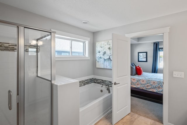 ensuite bathroom with a shower stall, a textured ceiling, ensuite bathroom, and a garden tub