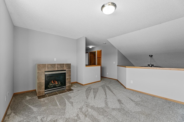 unfurnished living room with baseboards, carpet, a fireplace, and a textured ceiling