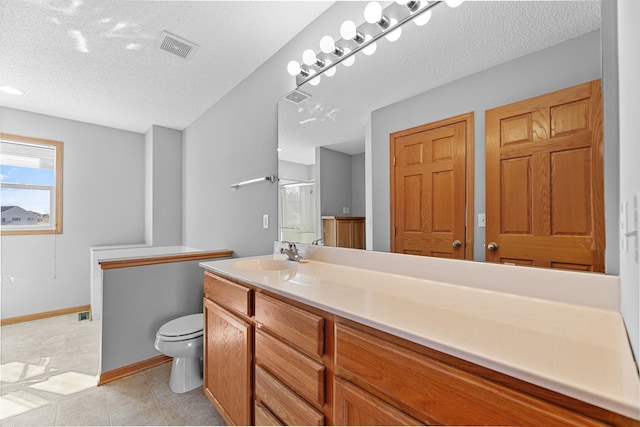 bathroom with tile patterned flooring, visible vents, toilet, vanity, and a textured ceiling