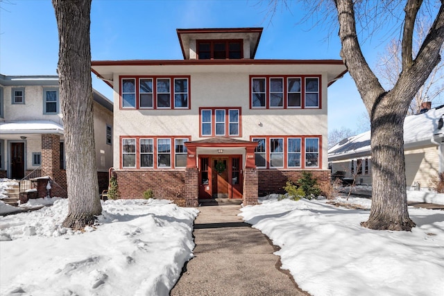 american foursquare style home featuring brick siding and stucco siding