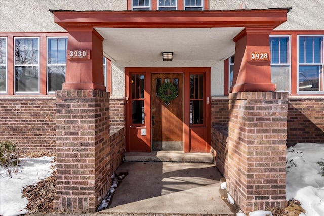 view of exterior entry with brick siding