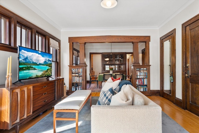 living room with baseboards, wood finished floors, and ornamental molding