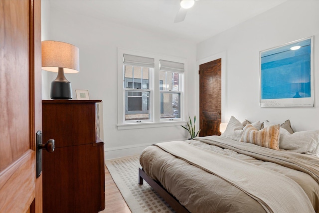 bedroom with ceiling fan, baseboards, and wood finished floors