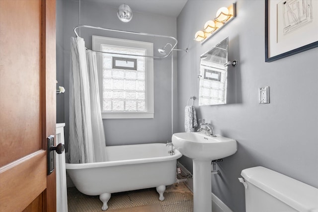 full bathroom featuring a shower with curtain, toilet, and a freestanding bath