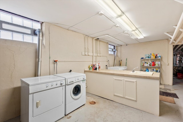 washroom with washer and dryer, laundry area, and a sink