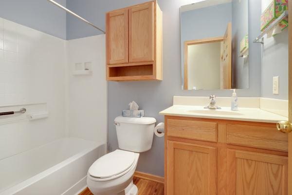 full bathroom with wood finished floors, toilet, shower / washtub combination, and vanity