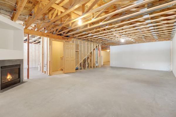 unfinished basement with a fireplace with flush hearth