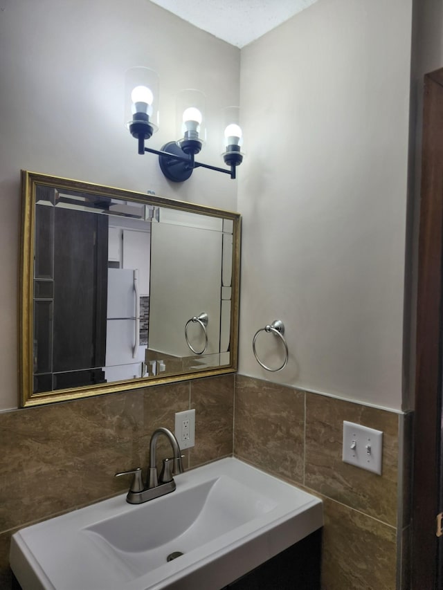 bathroom with vanity and tile walls