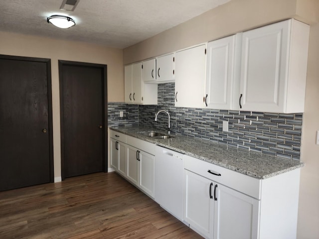 kitchen with a sink, light stone counters, dark wood-style floors, white cabinets, and dishwasher