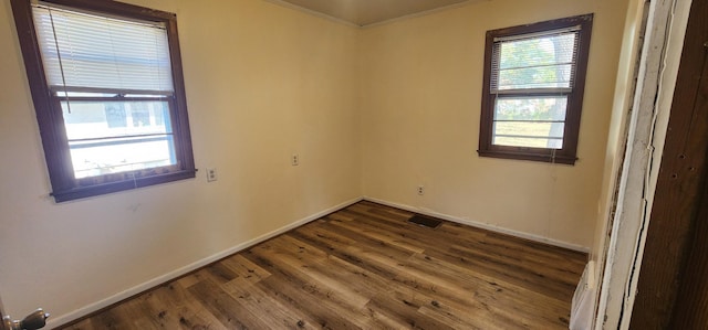 spare room with visible vents, dark wood-style flooring, and baseboards