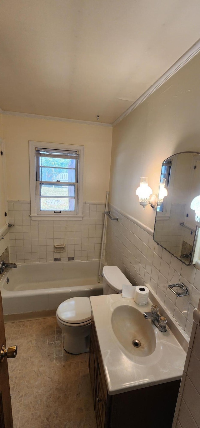 bathroom with vanity, ornamental molding, wainscoting, tile walls, and toilet