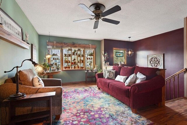 living area featuring a ceiling fan, wood finished floors, and a textured ceiling