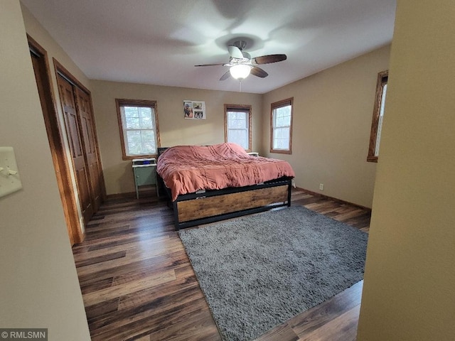 bedroom featuring multiple windows, dark wood-type flooring, and ceiling fan