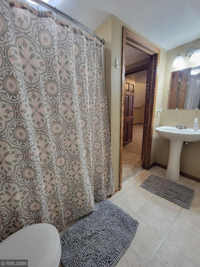 full bathroom with a shower with shower curtain, toilet, baseboards, and tile patterned floors