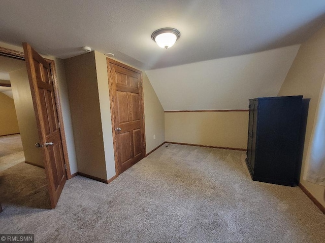 bonus room featuring baseboards, light colored carpet, and vaulted ceiling