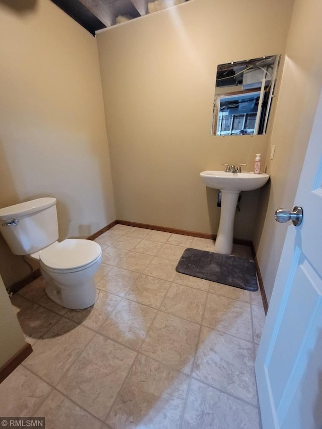 bathroom with toilet and baseboards