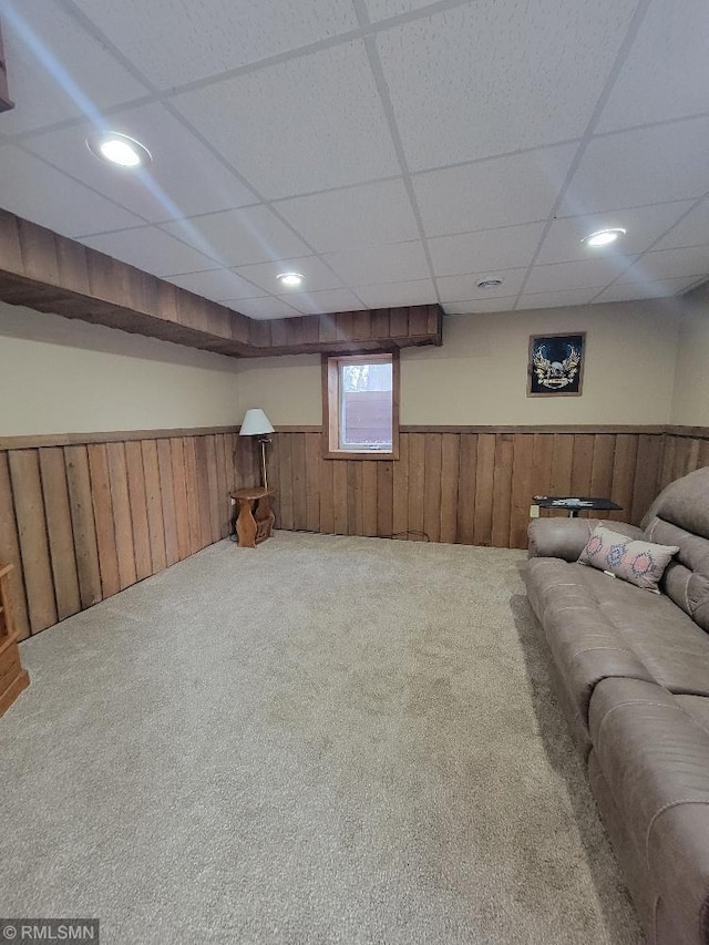 carpeted living room with a wainscoted wall, recessed lighting, a paneled ceiling, and wooden walls