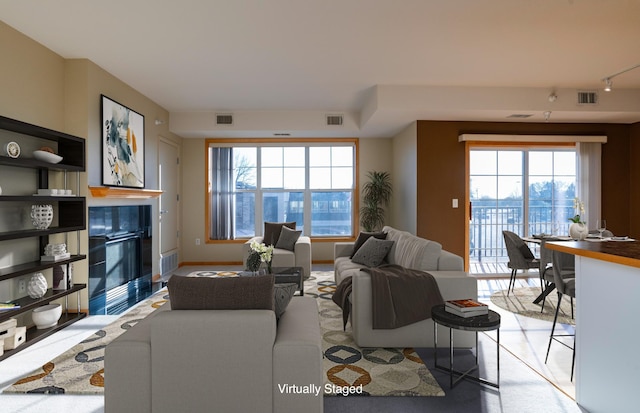 living area featuring baseboards, visible vents, and a tile fireplace