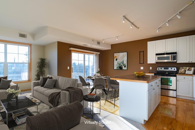 kitchen featuring visible vents, appliances with stainless steel finishes, and open floor plan