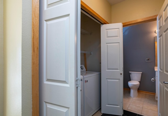 bathroom featuring tile patterned flooring, toilet, baseboards, and independent washer and dryer