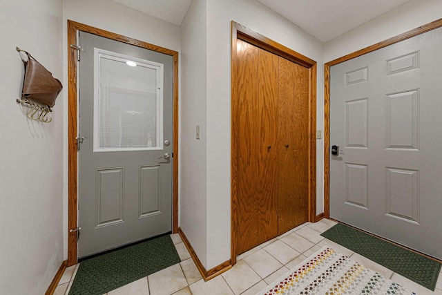 entryway featuring light tile patterned floors and baseboards