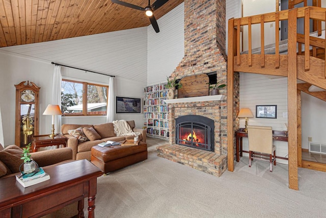 living room with visible vents, carpet floors, high vaulted ceiling, a fireplace, and wood ceiling