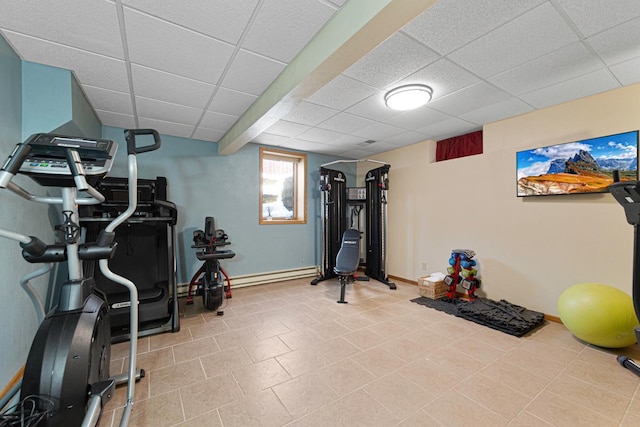 workout area with a drop ceiling, baseboards, and a baseboard radiator