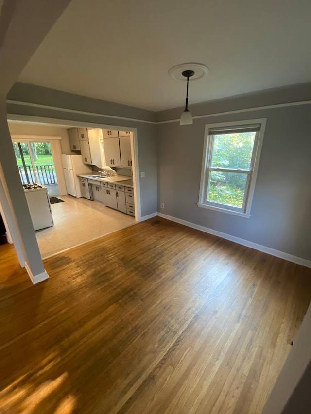 unfurnished living room featuring light wood-type flooring and baseboards