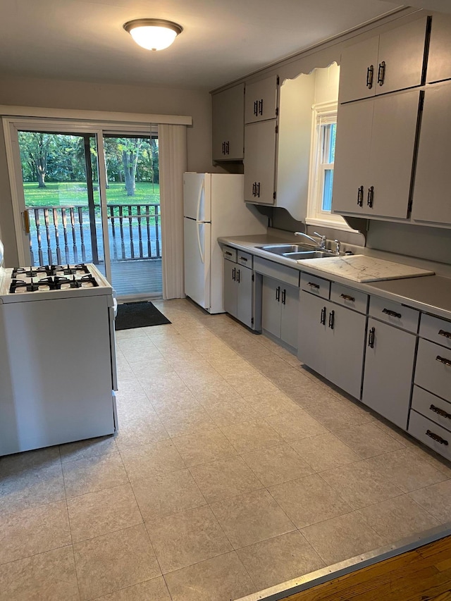 kitchen with a sink, white appliances, and light countertops