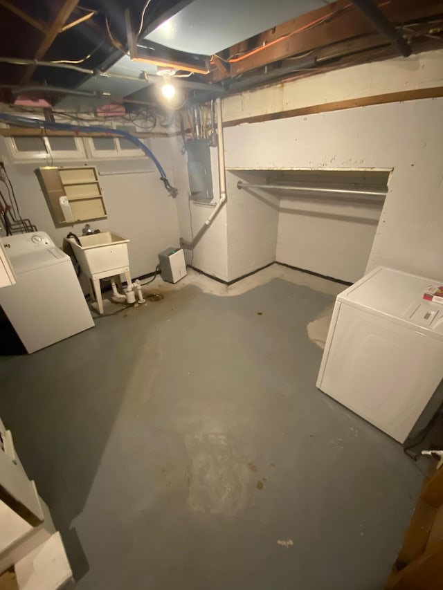 unfinished below grade area with electric panel, washer and dryer, and a sink