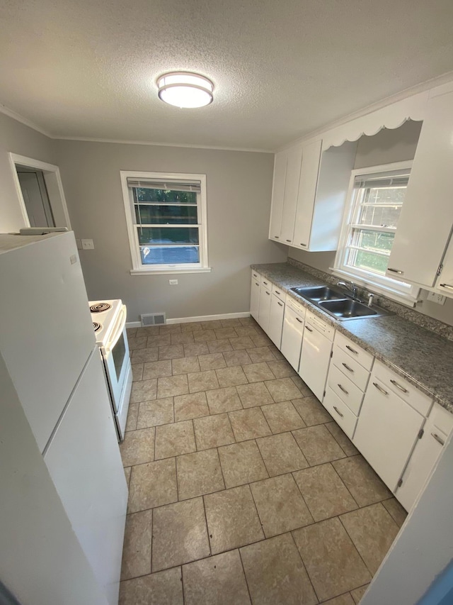 kitchen with visible vents, white cabinets, white appliances, a textured ceiling, and a sink